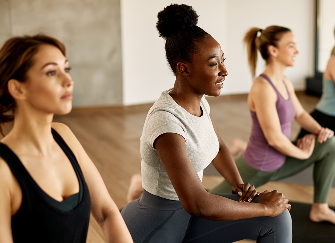 Employee Benefits - Group of Women at a Gym Doing Stretches